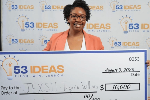 Jexsii founder holding large check in the amount of $10,000